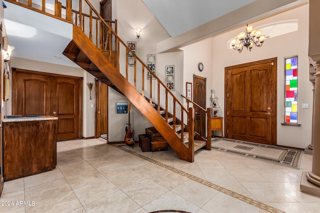 entryway featuring a chandelier, light tile patterned flooring, and high vaulted ceiling