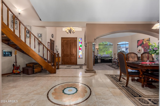 entrance foyer with ornate columns, an inviting chandelier, and light tile patterned floors