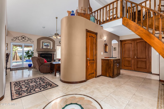 tiled entrance foyer featuring ceiling fan and high vaulted ceiling