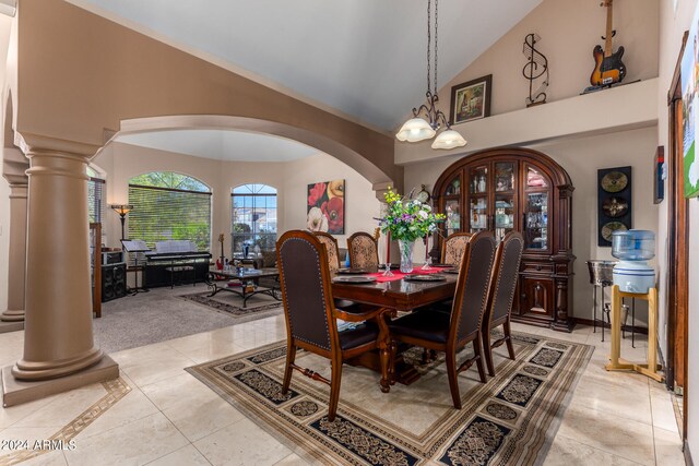 tiled dining area with an inviting chandelier, ornate columns, and high vaulted ceiling