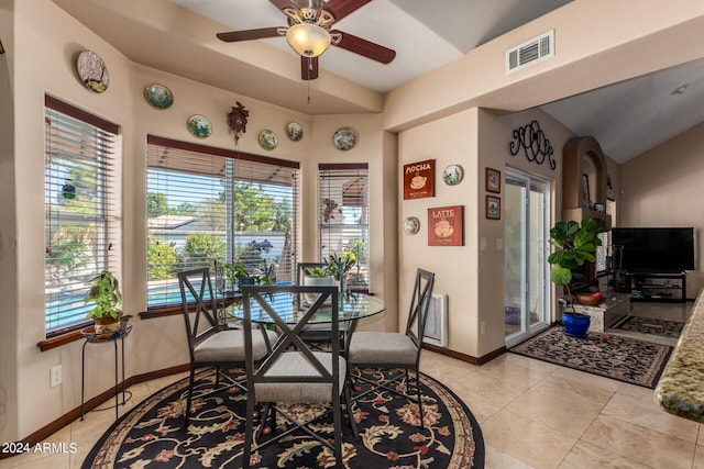 dining room with a healthy amount of sunlight, light tile patterned floors, vaulted ceiling, and ceiling fan