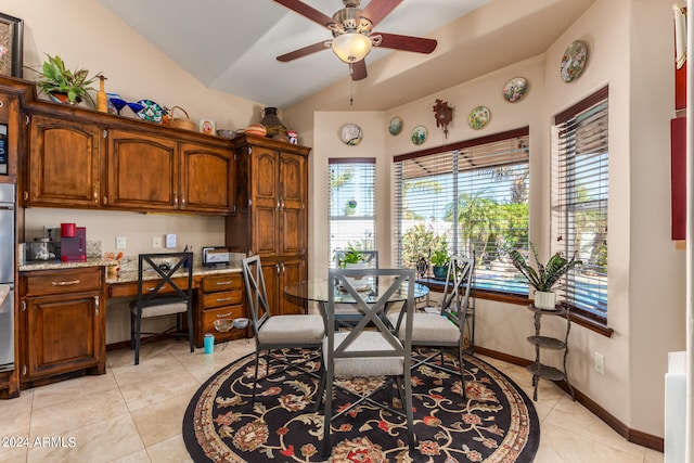 tiled dining room featuring ceiling fan and vaulted ceiling