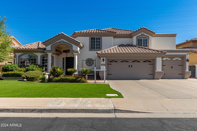 mediterranean / spanish-style home featuring a front lawn and a garage