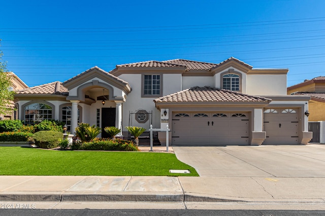 mediterranean / spanish home featuring a front yard, central AC, and a garage