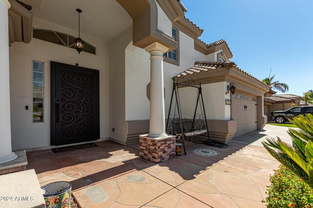 doorway to property with a porch and a garage