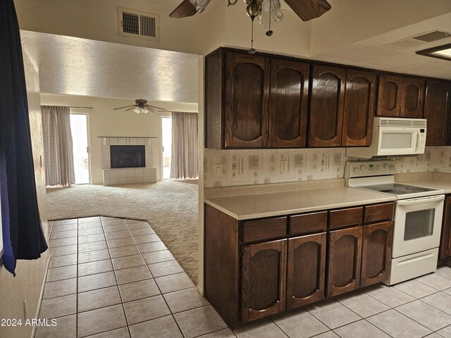 kitchen featuring light carpet, white appliances, ceiling fan, and dark brown cabinetry