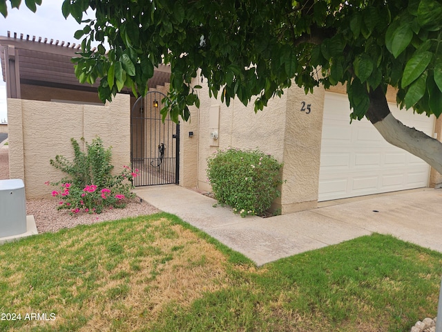 entrance to property featuring a lawn and a garage