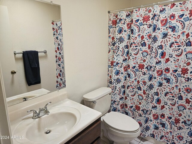 bathroom featuring a shower with shower curtain, vanity, toilet, and tile patterned floors