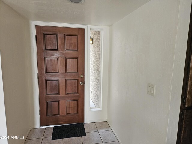 foyer with a textured ceiling and light tile patterned flooring