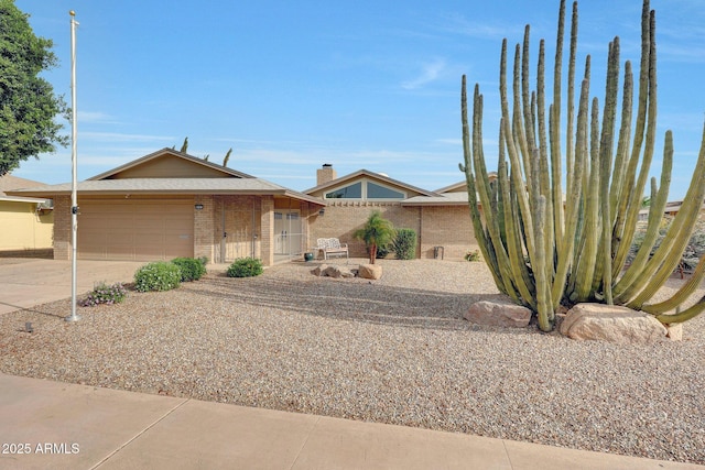view of front of home with an attached garage, brick siding, and concrete driveway
