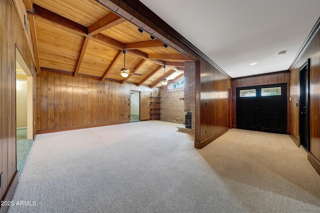 bonus room with carpet flooring, wooden walls, a ceiling fan, vaulted ceiling with beams, and wooden ceiling
