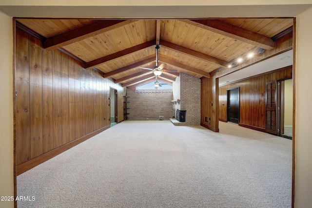 additional living space with wood walls, a brick fireplace, a ceiling fan, elevator, and vaulted ceiling with beams