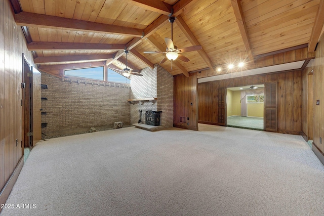 unfurnished living room featuring lofted ceiling with beams, a fireplace, ceiling fan, and wooden walls