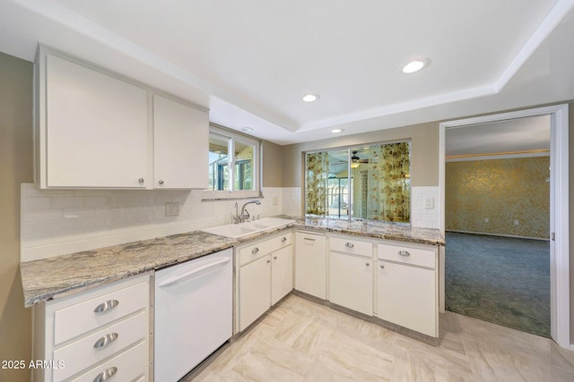 kitchen with dishwasher, a sink, white cabinetry, and backsplash