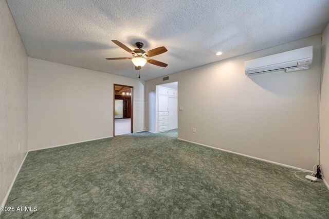 unfurnished bedroom with an AC wall unit, baseboards, a textured ceiling, carpet floors, and visible vents