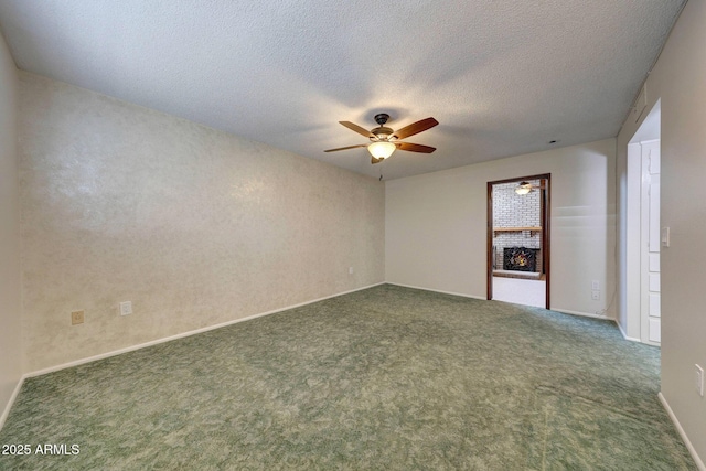 unfurnished room with a textured ceiling, dark carpet, and a ceiling fan