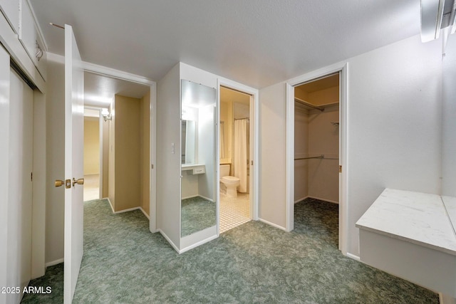 interior space featuring a spacious closet, toilet, and baseboards