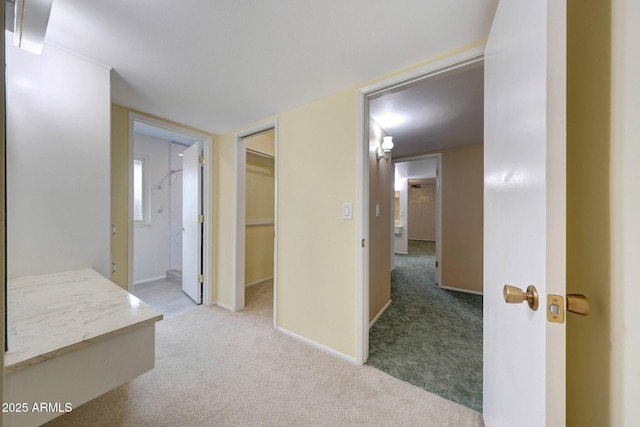 corridor with light colored carpet and baseboards