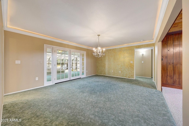 carpeted empty room with baseboards, crown molding, and an inviting chandelier