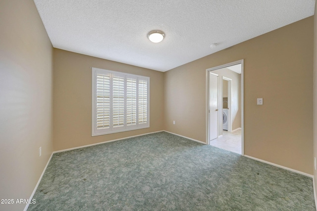 carpeted empty room with baseboards, washer / clothes dryer, and a textured ceiling