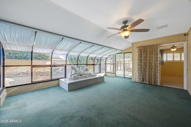 unfurnished sunroom with carpet floors, visible vents, and a ceiling fan