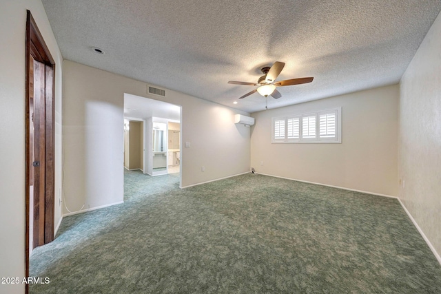 carpeted spare room with a ceiling fan, a textured ceiling, baseboards, visible vents, and an AC wall unit
