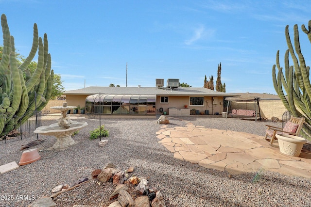 rear view of house with central air condition unit, fence, and a patio area