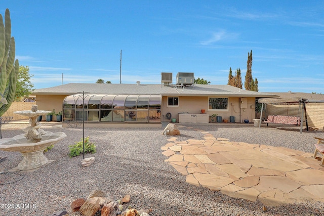 back of house with a sunroom, central air condition unit, and a patio area