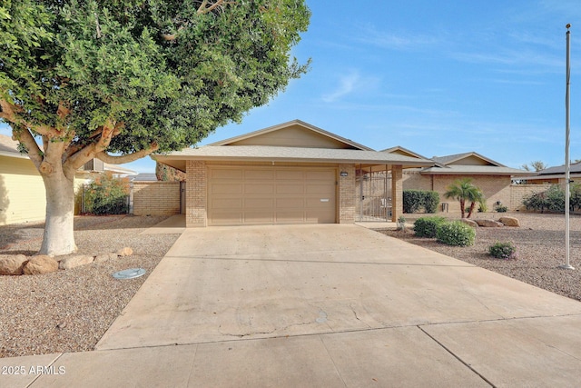 single story home with brick siding, concrete driveway, fence, and an attached garage