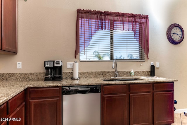 kitchen featuring dishwasher, light tile patterned floors, light stone counters, and sink