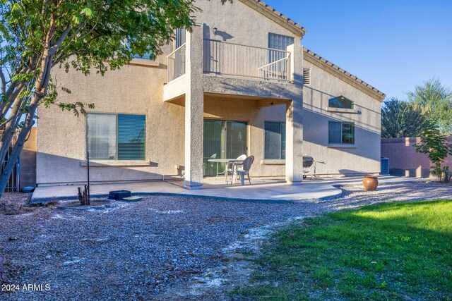 rear view of house featuring a patio area, a balcony, and central AC