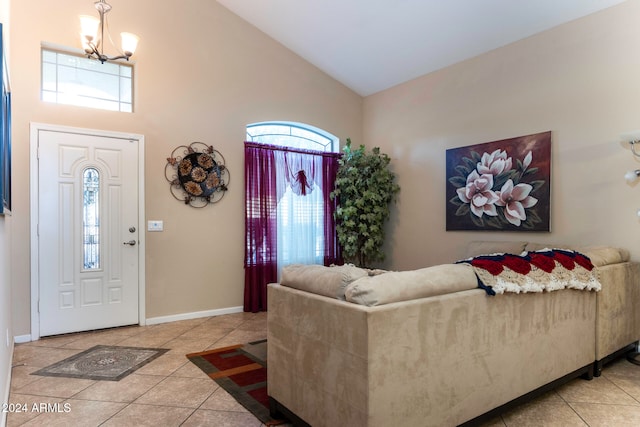 entrance foyer with light tile patterned flooring, high vaulted ceiling, and a chandelier