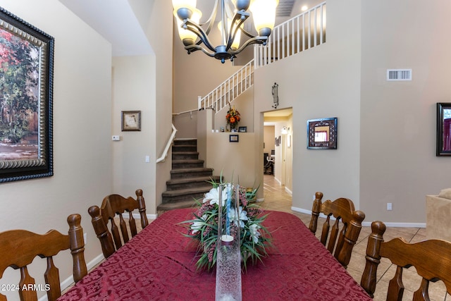 tiled dining space featuring a towering ceiling and a chandelier