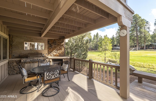 wooden deck with outdoor dining area, a lawn, and area for grilling