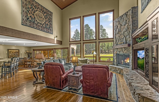 living room with recessed lighting, high vaulted ceiling, a fireplace, and hardwood / wood-style flooring