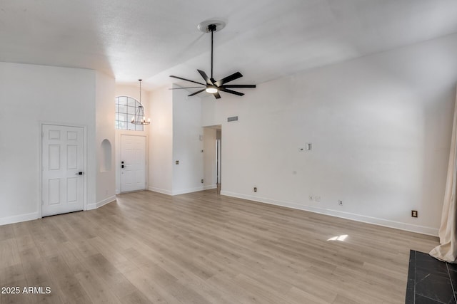 4443 W Escuda Dr, Glendale, AZ 85308 - unfurnished living room with a ceiling fan, a chandelier, light wood-style flooring, baseboards, and high vaulted ceiling
