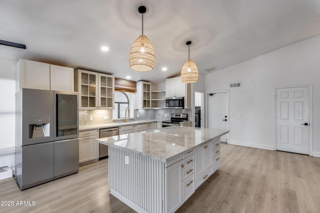 4443 W Escuda Dr, Glendale, AZ 85308 - kitchen with appliances with stainless steel finishes, light wood-type flooring, tasteful backsplash, white cabinets, and vaulted ceiling