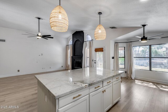 4443 W Escuda Dr, Glendale, AZ 85308 - kitchen with ceiling fan, vaulted ceiling, light wood-style floors, hanging light fixtures, and baseboards