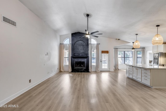 4443 W Escuda Dr, Glendale, AZ 85308 - unfurnished living room featuring a ceiling fan, vaulted ceiling, light wood-style flooring, baseboards, and a large fireplace
