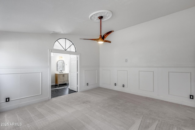 4443 W Escuda Dr, Glendale, AZ 85308 - empty room with a decorative wall, carpet, a ceiling fan, and wainscoting
