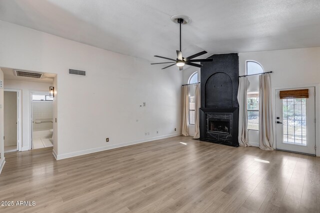4443 W Escuda Dr, Glendale, AZ 85308 - unfurnished living room with a ceiling fan, vaulted ceiling, light wood finished floors, a fireplace, and baseboards