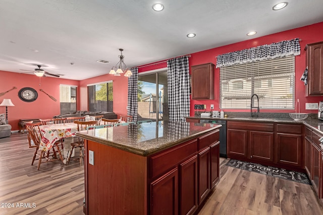 kitchen featuring a center island, sink, hanging light fixtures, hardwood / wood-style flooring, and dishwashing machine