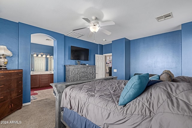 carpeted bedroom featuring ceiling fan and ensuite bathroom