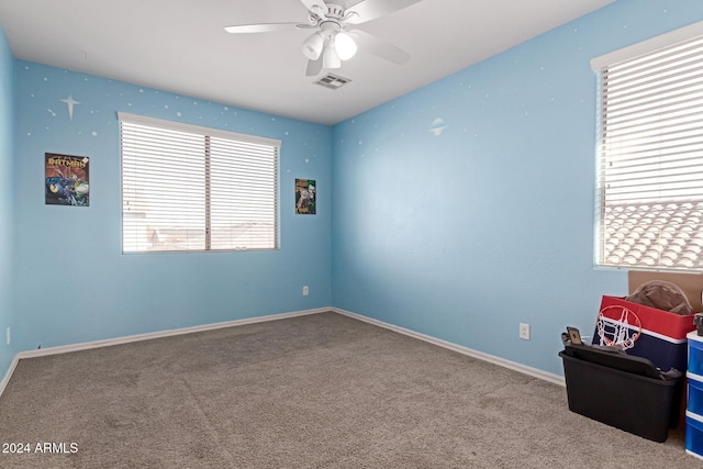 carpeted empty room featuring ceiling fan