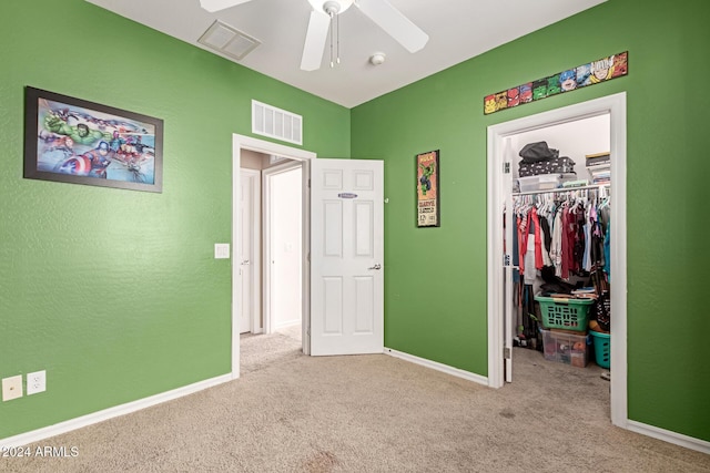 unfurnished bedroom with ceiling fan, light colored carpet, and a closet