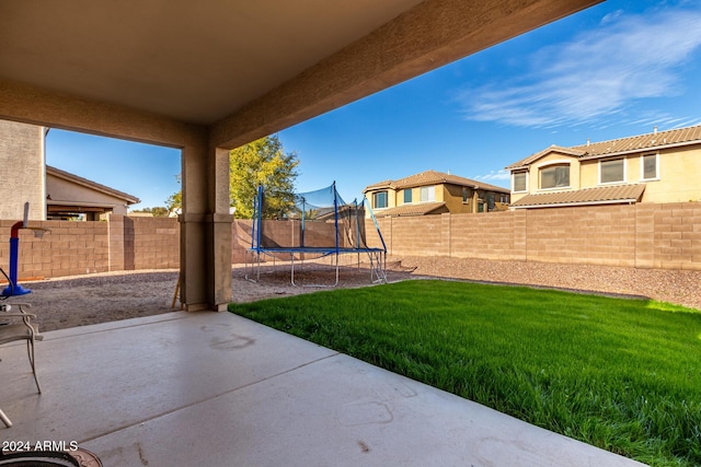 view of yard with a trampoline and a patio area