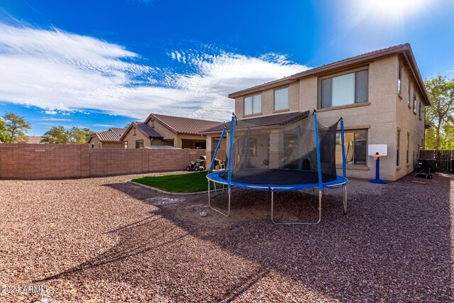 rear view of property featuring a trampoline