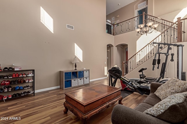 living room featuring hardwood / wood-style floors, a high ceiling, and an inviting chandelier