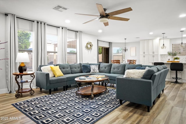 10617 W Daley Ln, Peoria, AZ 85383 - living room featuring healthy amount of natural light, light wood-type flooring, a ceiling fan, and recessed lighting