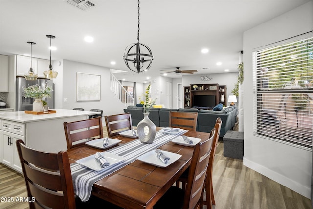 10617 W Daley Ln, Peoria, AZ 85383 - dining area with light wood-style floors, a chandelier, ceiling fan, stairs, and baseboards
